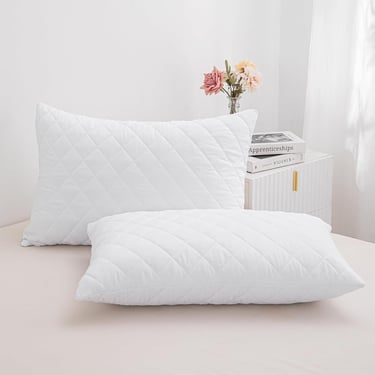 a pair of pillows and pillows on a bed