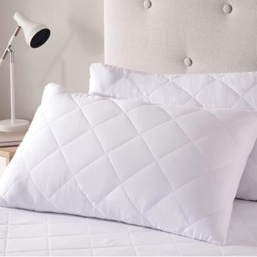 a bed with a white pillow and pillows