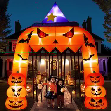 a couple of kids standing in front of a halloween themed archway