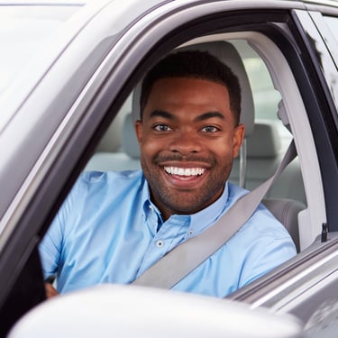 Motorista sorridente no carro APKTEM, transporte por aplicativo urbano.