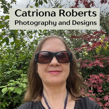 Image of a woman standing infront of shrubs.