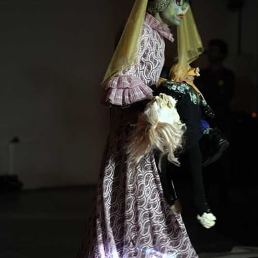 David Noir portant le mannequin de l'enfant | Votre enfant n'a qu'un oeil | Photo Bernard Bousquet