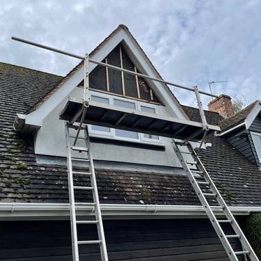 a pitched roof with large pitched dormer window. small scaffolding is erected in front of window