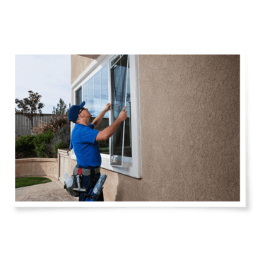 a man in a blue shirt is installing a window
