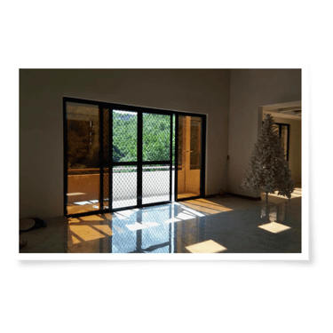 a room with a christmas tree and newly installed aluminum frame door