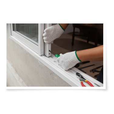 a person wearing gloves fixing a sliding door