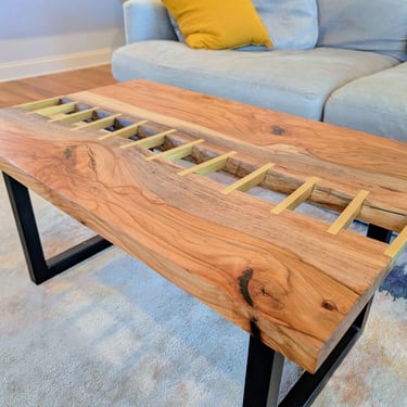 living room shot of pecan river table with solid brass inlay bars and black metal legs