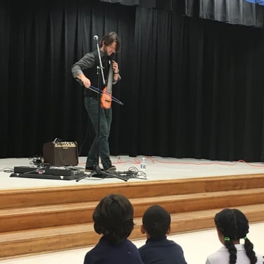 cellist Wytold performs at a school
