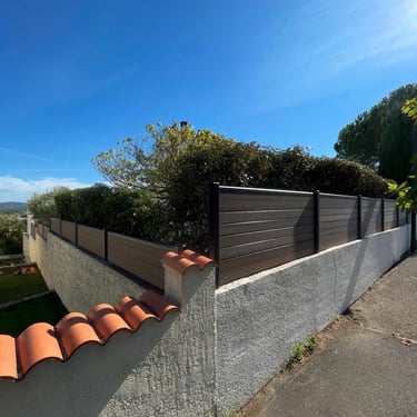 Clôture composite et portail bordant une allée extérieure