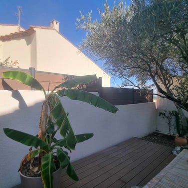 Clôture composite anthracite délimitant une terrasse aménagée