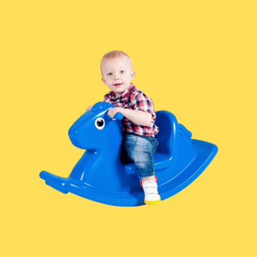 a baby boy sitting on a rocking horse