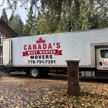 Canada’s Most Wanted Movers truck positioned outside a large brick home for a residential move in Langley..