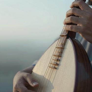 Macro close-up of a hand resting on the wooden neck of a traditional rabab, soft morning light, shallow depth of field, 35mm