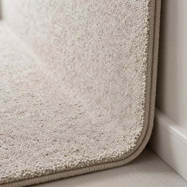 Soft, high-quality textile carpeting neatly cut and installed along a clean baseboard