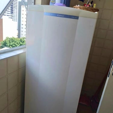 Geladeira branca vertical em área externa, exemplo de conserto em Curitiba.