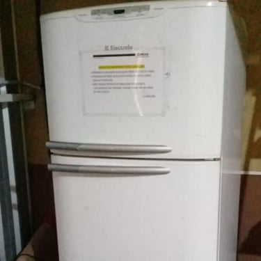 Geladeira branca Electrolux com adesivo de aviso, manutenção em Curitiba.