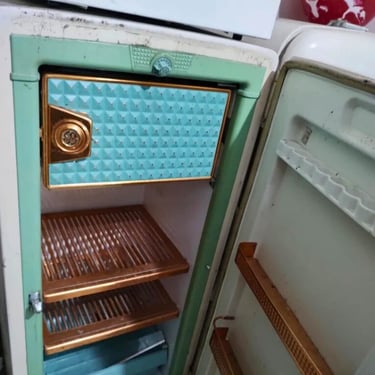 Geladeira antiga aberta com prateleiras de cobre, pronta para reparo em Curitiba.