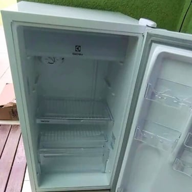 Freezer branco aberto em área externa, manutenção de refrigeradores em Curitiba.