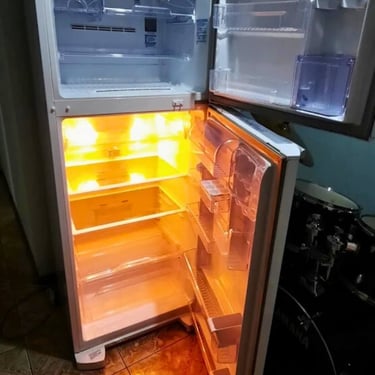 Geladeira acesa com lâmpada interna, pronta para reparo em Curitiba.