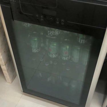 Frigobar preto com porta de vidro, usado em serviços de conserto de geladeira em Curitiba.