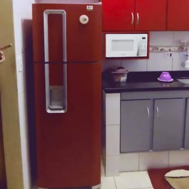 Geladeira duplex vermelha em cozinha, exemplo de conserto de geladeira em Curitiba.