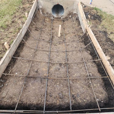 Concrete formwork with rebar for culvert channel.