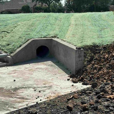 Concrete drainage culvert with erosion control matting.