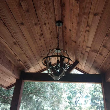 Wood-paneled gable ceiling with chandelier.