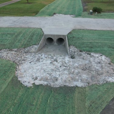 Concrete culvert with twin drainage pipes.