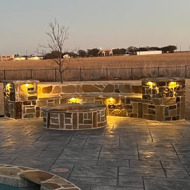 Stone fire pit on a stamped concrete patio.