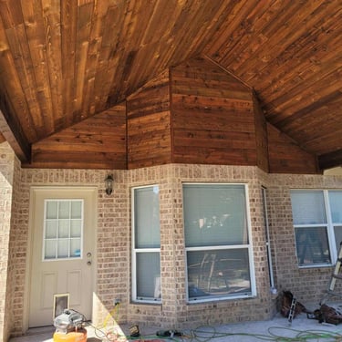 Covered patio area with stained wood vaulted ceiling.