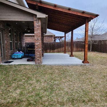 Brick house with a wooden patio cover over a concrete slab.