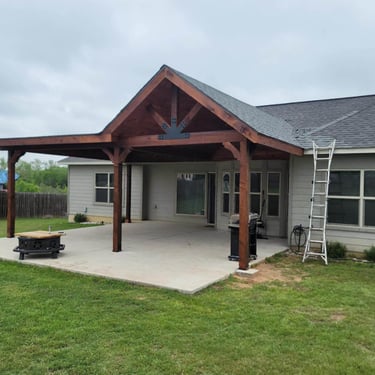 Covered backyard patio with wood gable roof.