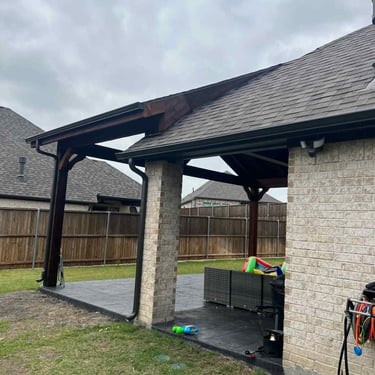 Covered patio extension with dark wood posts.