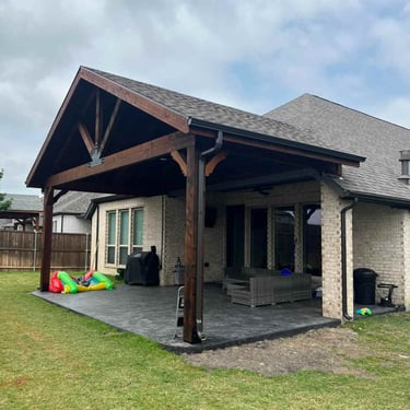 Gable-style covered patio with dark wood beams.