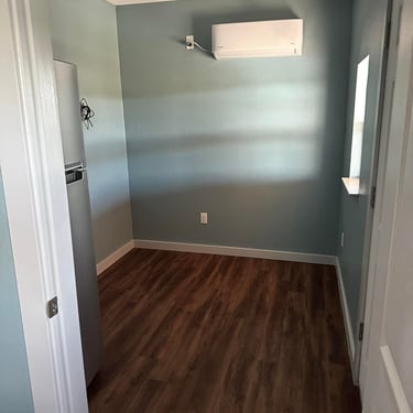 Small finished room with wood flooring.