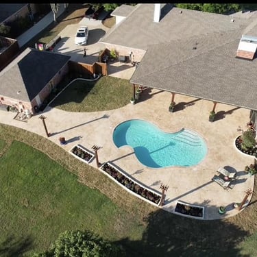 Aerial view of backyard with pool and patio.