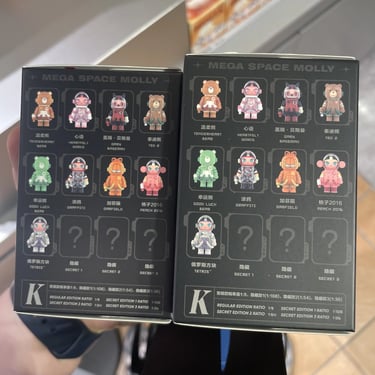 a person holding a two minifigure blind boxes