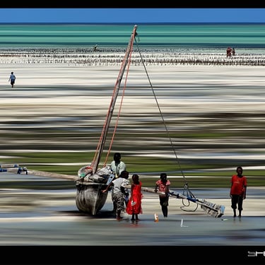 un voilier sur la plage avec des gens marchant sur la plage à Zanzibar