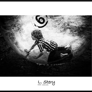un garçon jouant au football dans une piscine à balles. Photo noir et blanc de L  Stery
