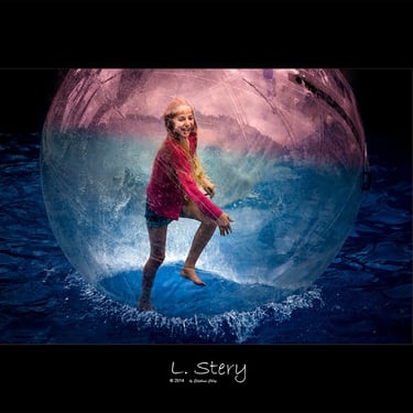 une fille blonde dans une bulles sur l'eau. photo couleur de L  Stery