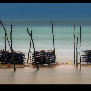 une rangée de casiers d'huitres sur une plage