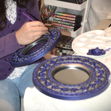 Closup of a mirror being painted by a young girl. No face visible