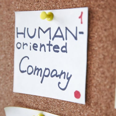 Post on wall saying human oriented company representing augusta precious metals having good values