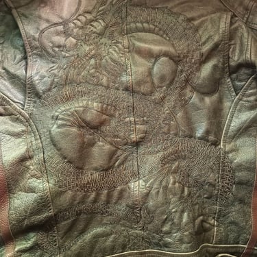 Pirograbado de dragón chino en chaquea de cuero.