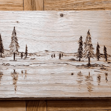 Pinos y lago, Pirograbado en tabla de madera 30 x 21 cm. Colección privada.