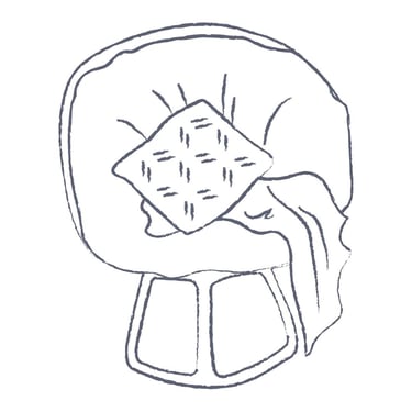 A simple line drawing of a cozy hypnosis armchair with a pillow and a soft throw blanket.
