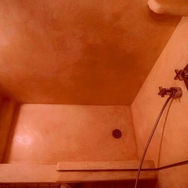 Moroccan Tadelakt shower floor polished wit olive oil soap and over stones.