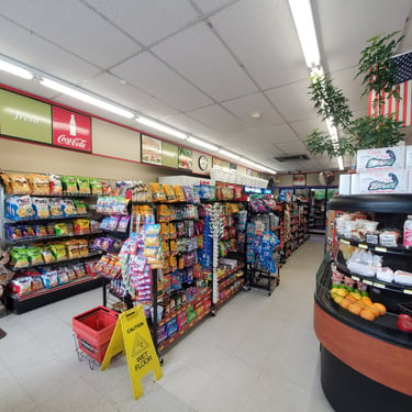 Photo of a brightly lit convenience store with shelves of snacks and candy