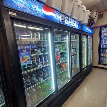 The fridge section of the convenience store showing different brands of soda